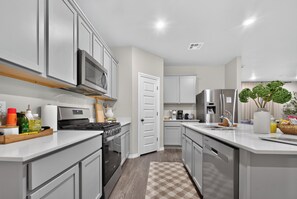 A modern kitchen with stainless steel appliances, a microwave, and a coffee maker.