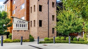 A brick building with a sign for 'Chelan Resort Suites'. - Waterfront 2-bed/2bath Suite w/Indoor Pool & Hot Tub (Chelan)