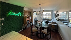 A modern living room with a green wall, a dining area with a round table, and a sofa. - Waterfront 2-bed/2bath Suite w/Indoor Pool & Hot Tub (Chelan)
