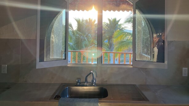 A bathroom with a sink, a mirror, and a window with an open door. - Explore this spacious 3-bedroom apartment with WiFi, AC in nice Perula (Perula)