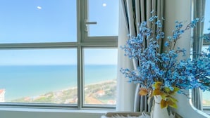 Ein Zimmer mit großem Fenster und Blick auf das Meer und die Küstenlandschaft.