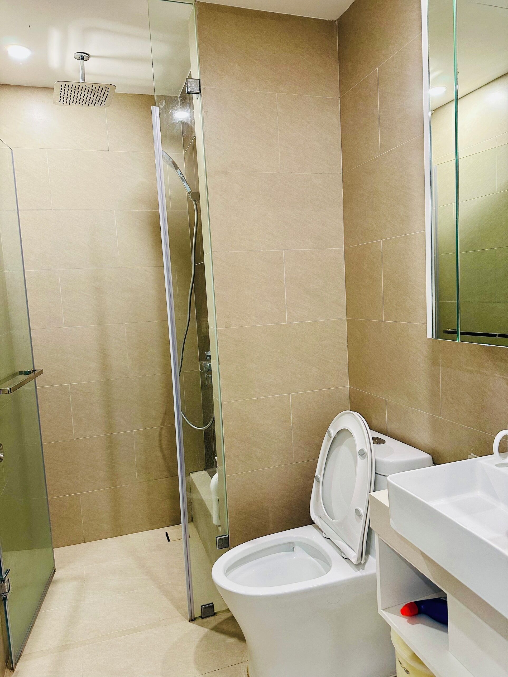 Un baño con ducha, inodoro y lavabo.