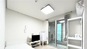 A hotel room with a bed, a TV, a desk, and a wardrobe. - Incheon airport W Premium guesthouse (Incheon)