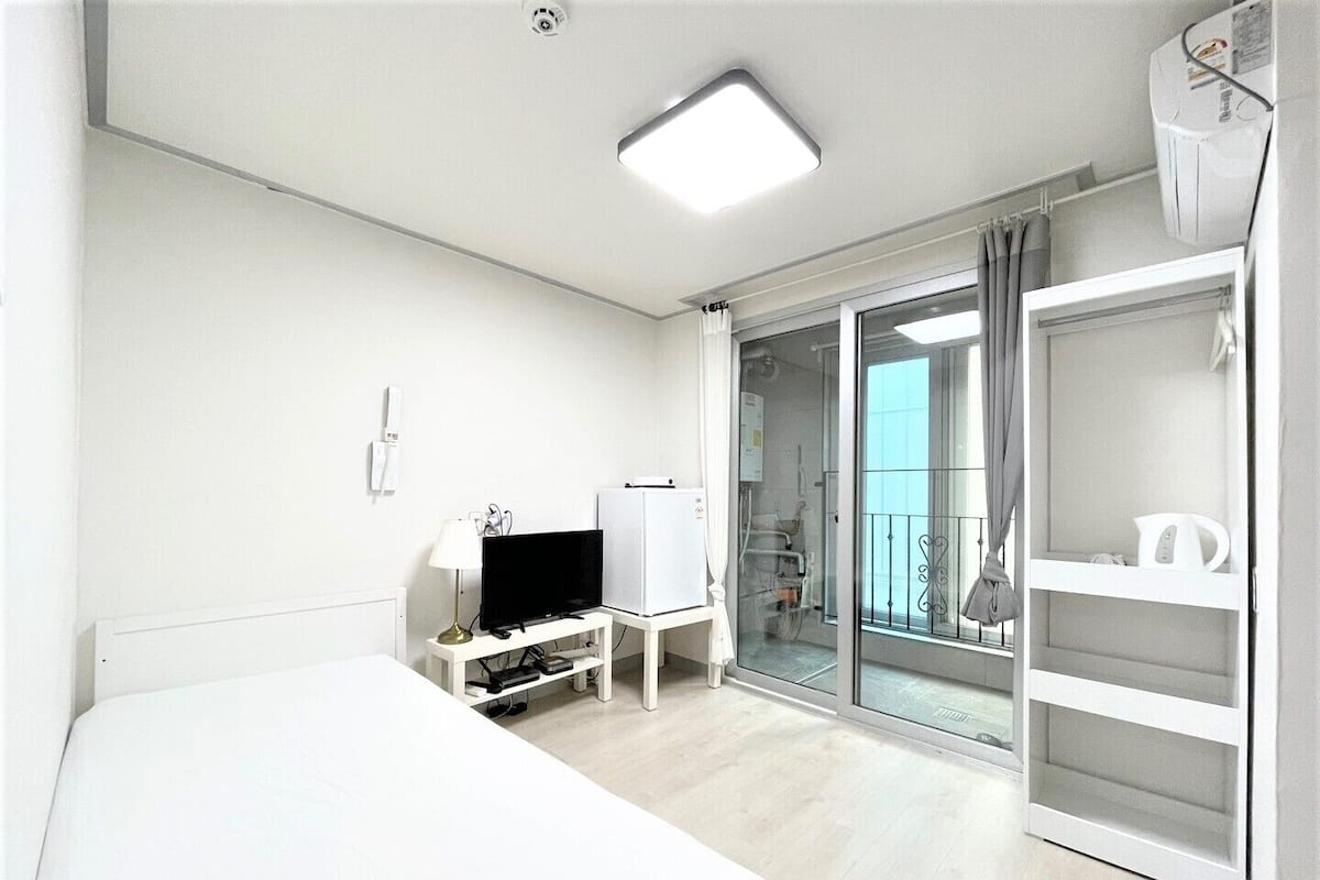 Une chambre d’hôtel équipée d’un lit, d’une télévision, d’un bureau et d’une armoire.