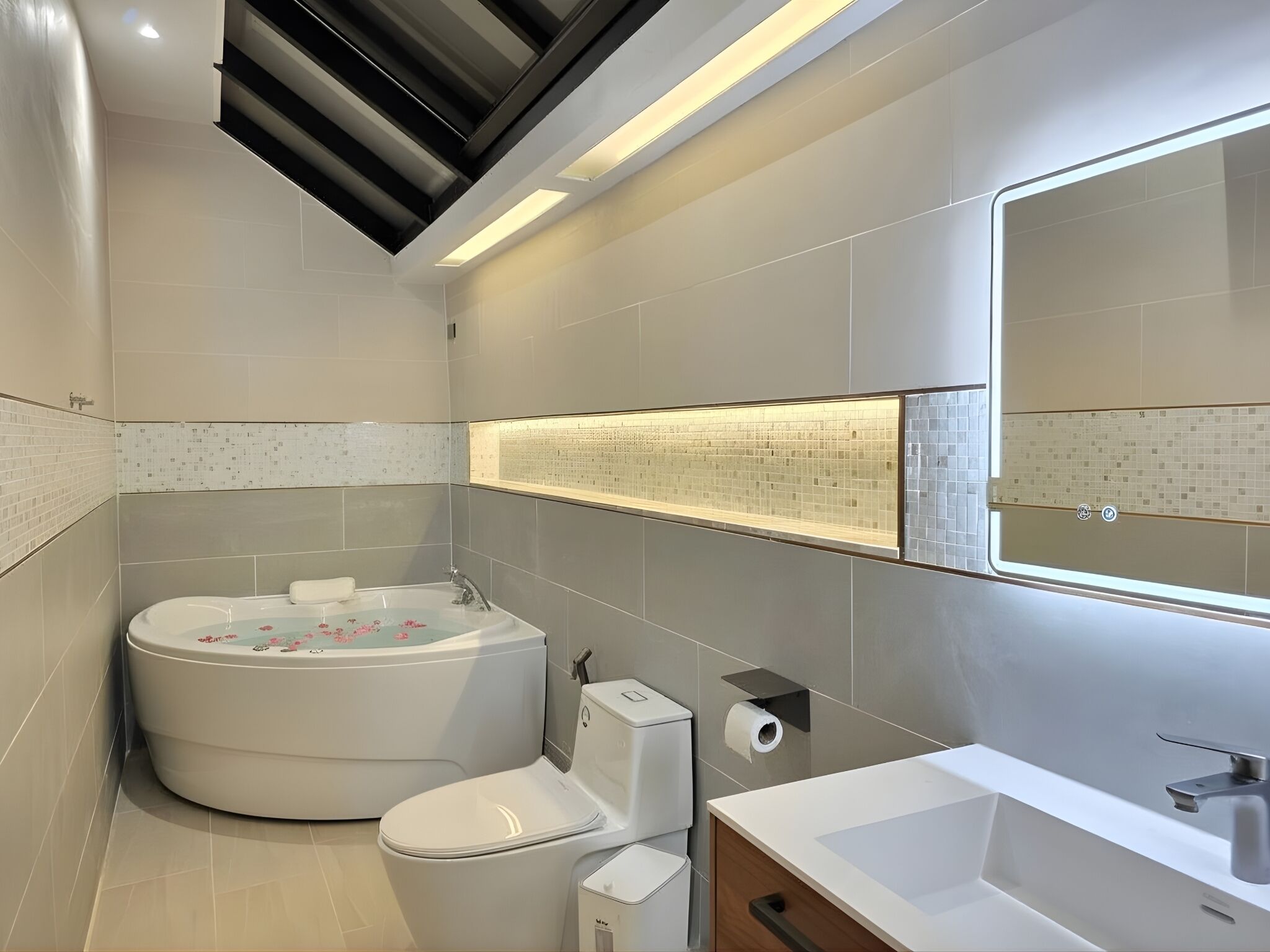A modern bathroom with a bathtub, toilet, and sink.