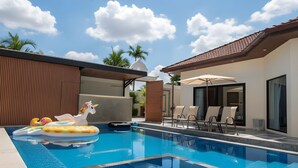 Piscina com espreguiçadeiras e um flutuador de unicórnio.