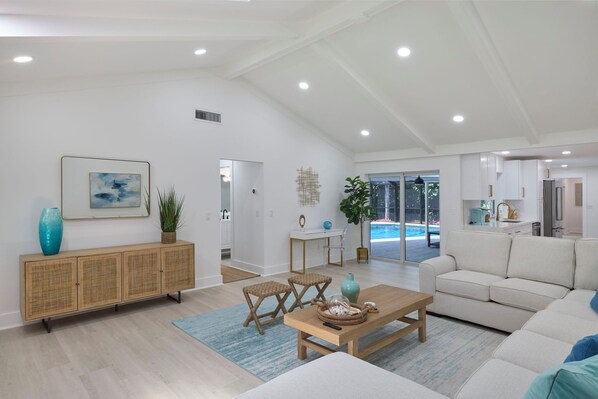 Relax in this stylish living room with a sofa, coffee table, and side table, offering a view of the outdoor pool.