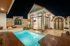 A modern house with a swimming pool, stone walls, and wooden deck. - Brand New 2BR Villa w/ Rice Field Views in Pererenan (Pererenan)