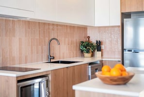 Een moderne keuken met een inbouwvaatwasser, een spoelbak en een roestvrijstalen koelkast.