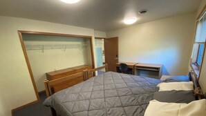 Ein Schlafzimmer mit einem Bett, einem Schreibtisch und einem Stuhl.