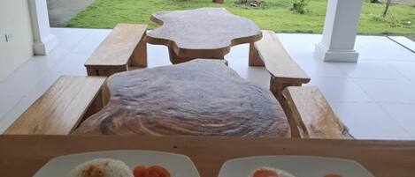 Un comedor con una mesa lista para dos personas, con platos de arroz y verduras.