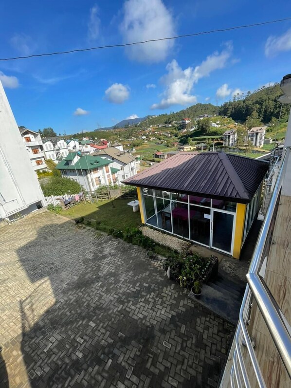 A view of a residential area with houses and a small building with a glass facade. - Villa Grand Mellow Nuwaraeliya (Nuwara Eliya)