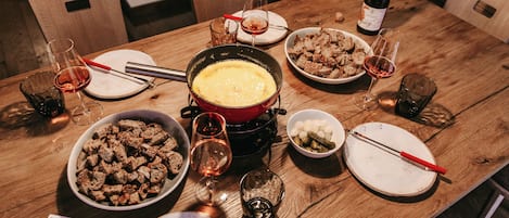 A dining table set with various dishes, glasses, and a bottle of wine.