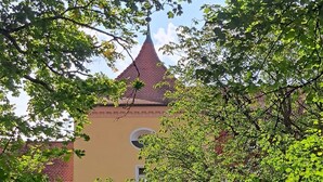 A building with a pointed roof, a gated entrance, and a pathway leading to it. - Apartment in the Ries with Wi-Fi (Wallerstein)