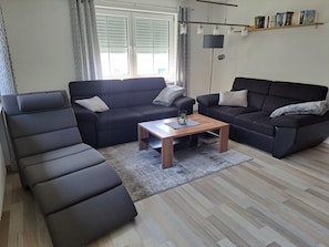 Un salon moderne comprenant un canapé, une table basse et une bibliothèque.