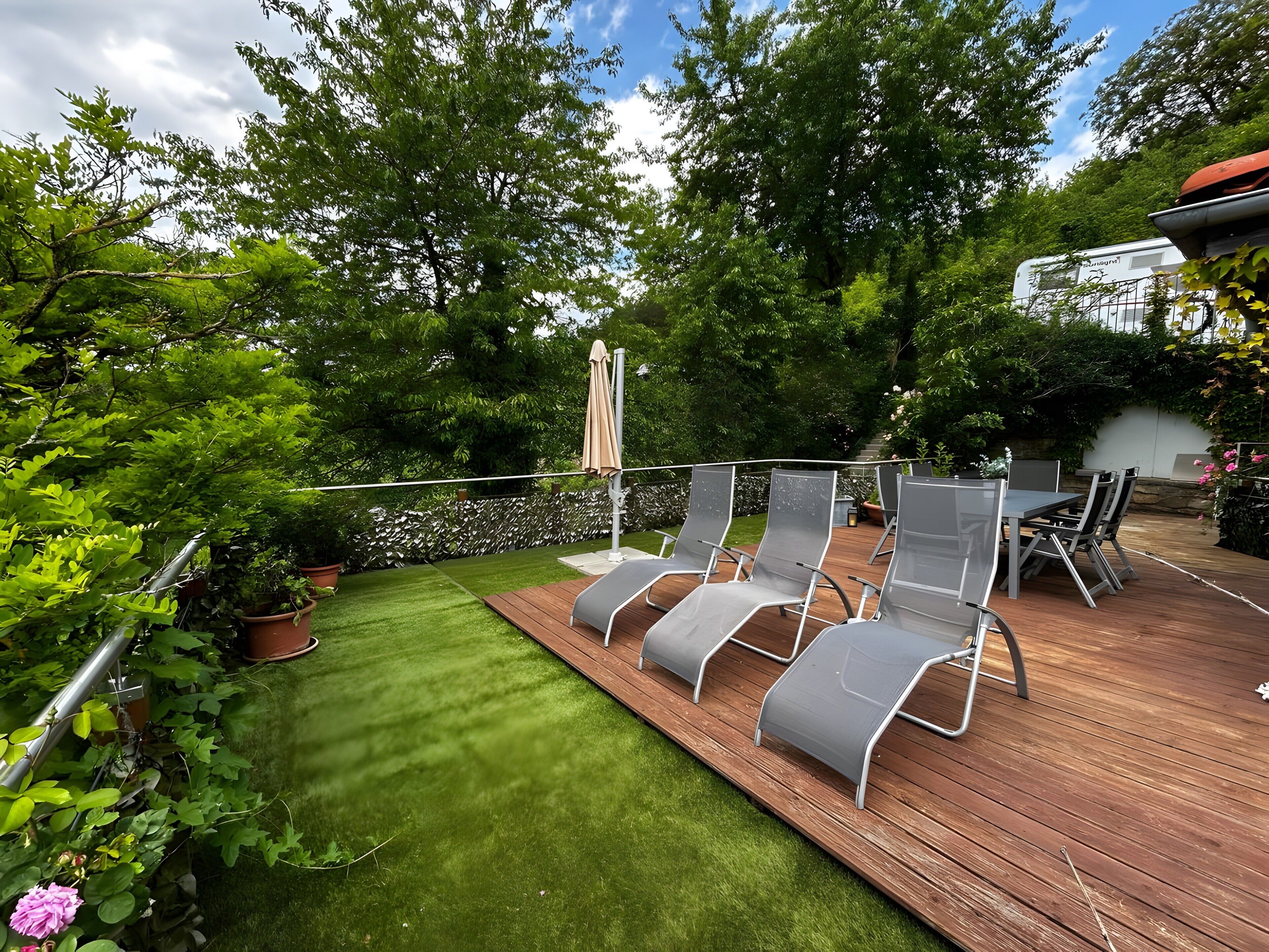 Una terraza con mobiliario exterior y un césped cuidado.