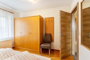 Une pièce comprenant un lit, une armoire, une chaise et une porte.