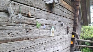 A rustic wooden wall with a bench, decorative items, and a small house-shaped ornament. - 'Adlerhütte' with Mountain View, Private Garden and Wi-Fi (Stieflberg)
