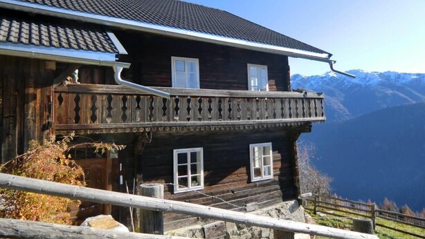 A wooden chalet with a balcony, a chimney, and a view of mountains. - 'Adlerhütte' with Mountain View, Private Garden and Wi-Fi (Stieflberg)