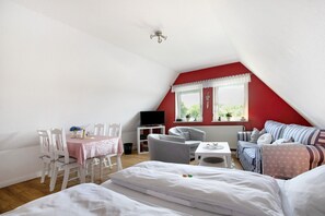 Une pièce comprenant une table à manger, des chaises, un canapé, un téléviseur et une fenêtre donnant sur un beau paysage.