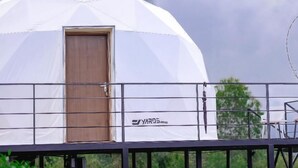 Una struttura a cupola bianca con una porta in legno, un corrimano in metallo e il marchio 'YAROS' ben visibile sul lato.