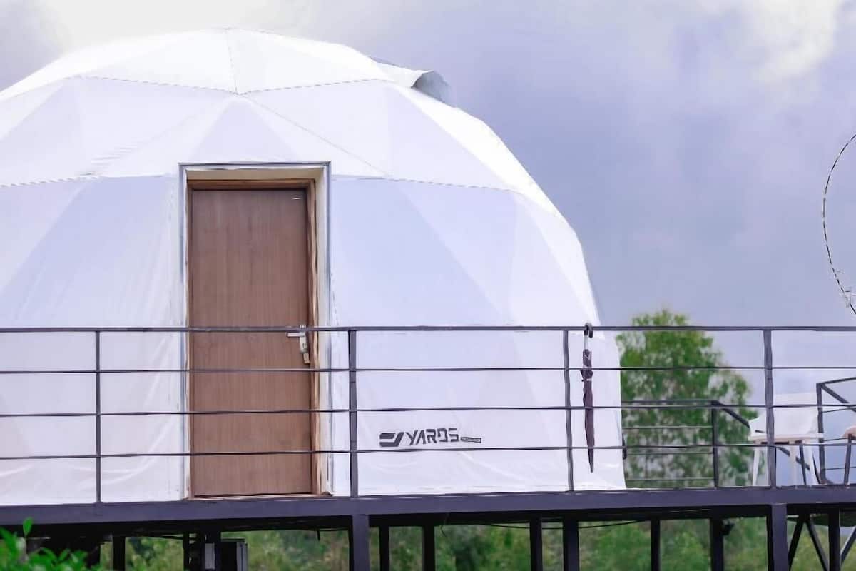 A white dome-shaped structure with a wooden door, a metal railing, and the brand name 'YAROS' visible on the side.