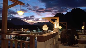 A night view of a resort with a pool, mountain backdrop, and a decorative elephant statue. - Phubarn VimarnVangvieng Resort (Vang Vieng)
