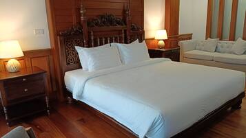 Una cama bien hecha con sábanas blancas, un cabecero de madera y dos lámparas de noche.