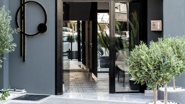 Un edificio moderno con un letrero que dice "KOSMOS LUXURY RESIDENCES".