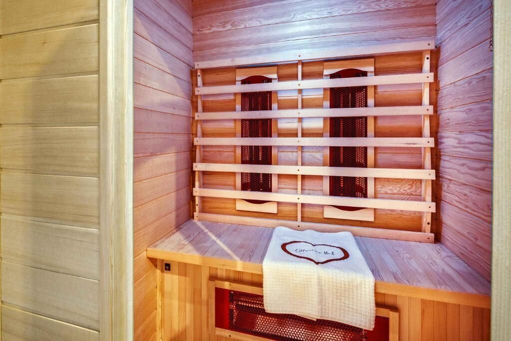 Una sauna con bancos de madera y una toalla con diseño de corazón.
