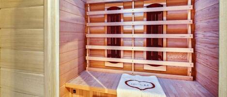 Una sauna con bancos de madera y una toalla con diseño de corazón.