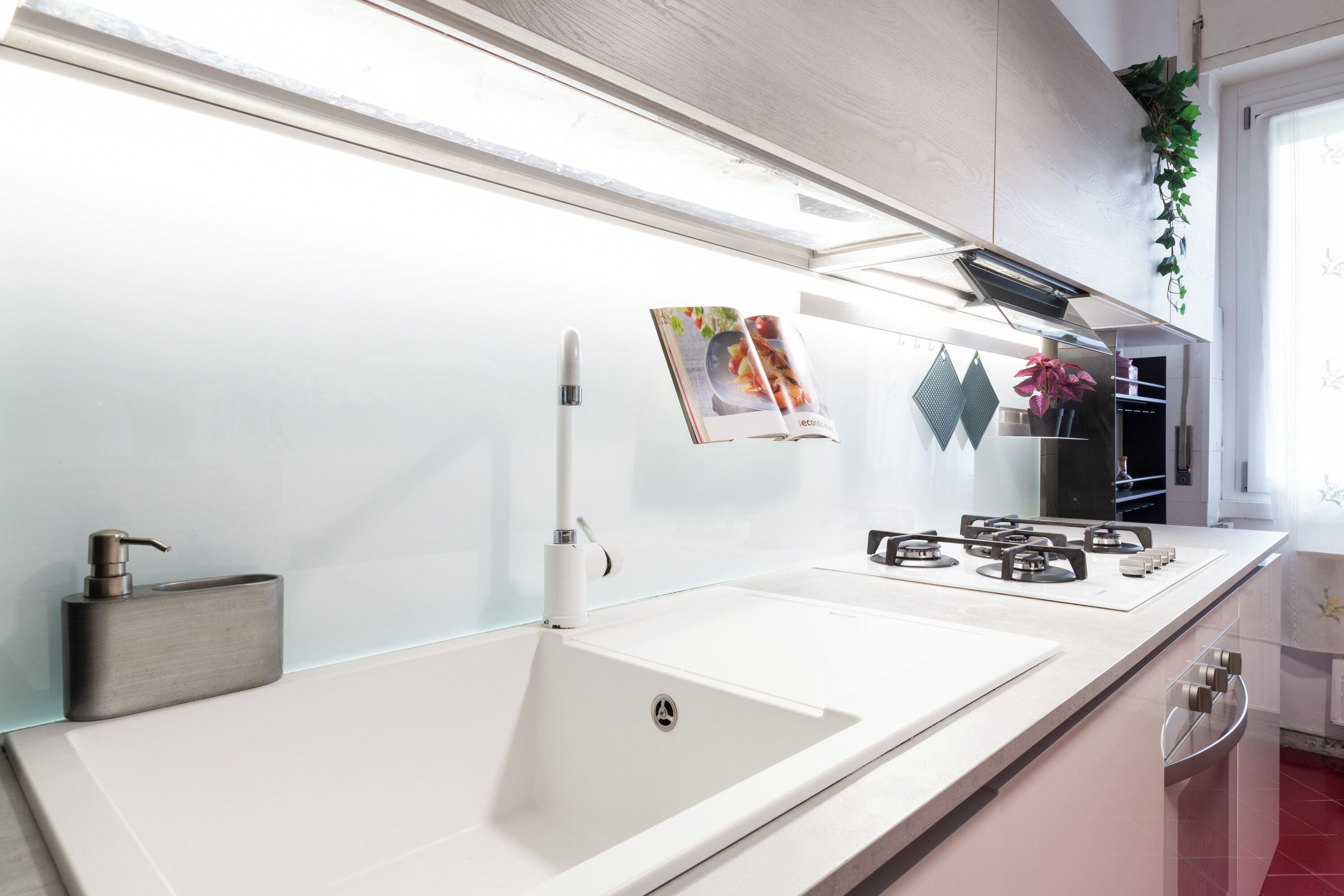 A modern kitchen with a white countertop, stainless steel appliances, and a built-in sink.
