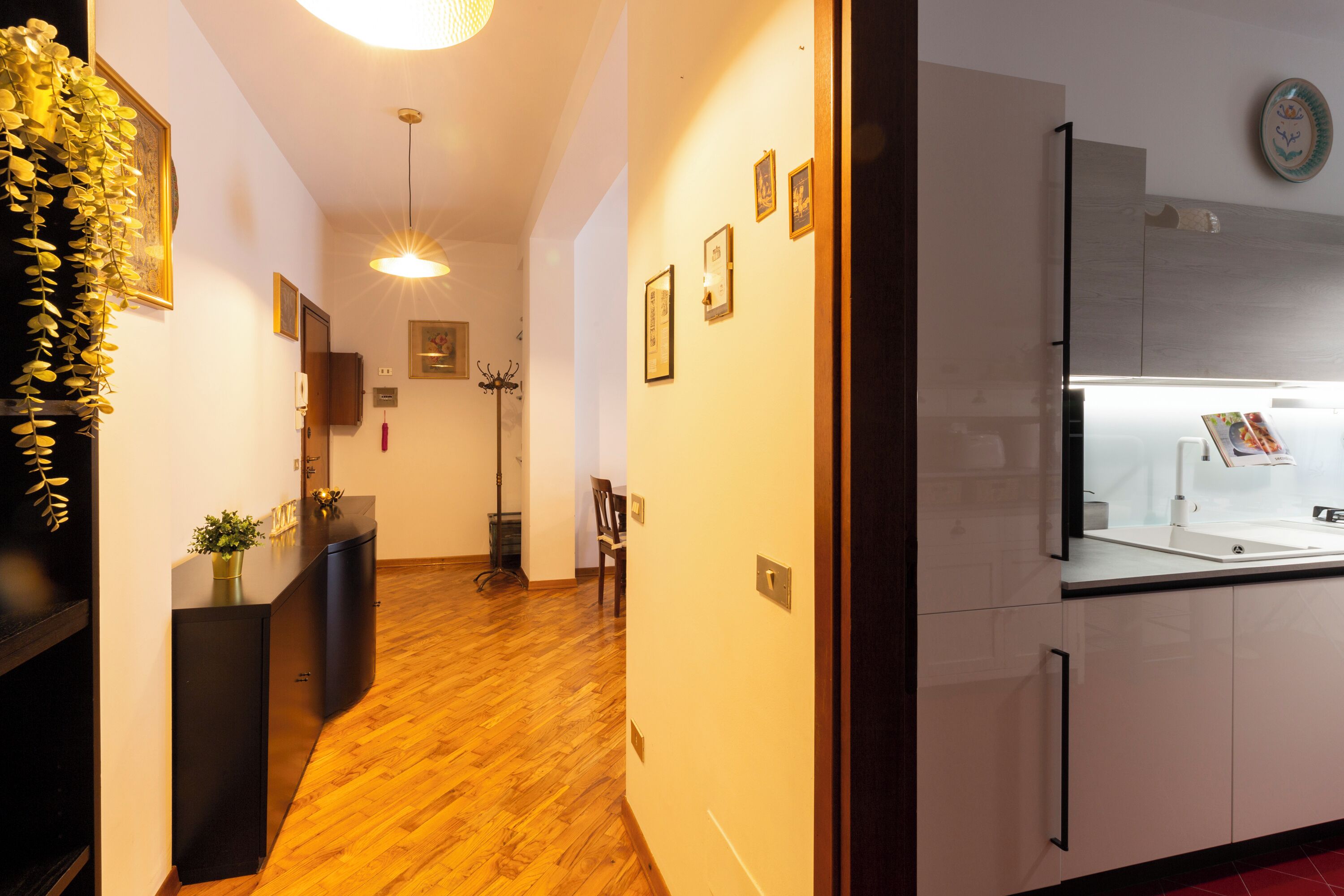 A modern kitchen with white cabinets, a built-in oven, and a microwave.