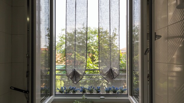 Ein Badezimmer mit Fenster, Dusche und Waschbecken.
