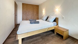 Un dormitorio con estructura de cama de madera, una mesita de noche y cabecera.