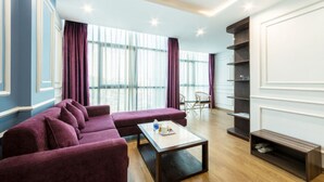 Ein modernes Wohnzimmer mit einem Ecksofa, einem Couchtisch und einem Bücherregal.