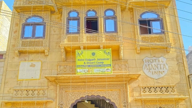 A traditional building with a sign for Hotel Rajgarh Jaisalmer & Desert Camp.