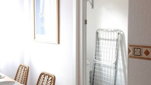 A room with wicker chairs, a framed picture on the wall, and a radiator. - 11A02 Casa RTPG  6p (Castrillon)