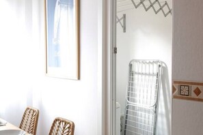 A room with wicker chairs, a framed picture on the wall, and a radiator. - 11A02 Casa RTPG  6p (Castrillon)