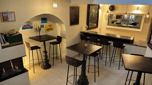 Una cocina moderna con comedor, que presenta una encimera de mármol, sillas negras y una isla central.