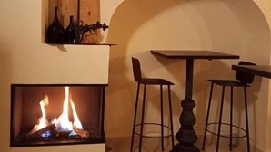 Una habitación acogedora con chimenea, una mesa y dos sillas.