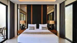 Ein modernes Hotelzimmer mit einem großen Bett, zwei Nachttischen, einem Schreibtisch und einem Stuhl.