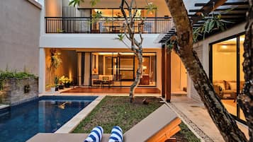 Una piscina al aire libre, sillones reclinables de piscina