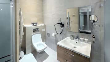 Un baño moderno con inodoro, lavabo y espejo.