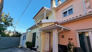 A residential building with a two-story structure, a visible door, and a small porch area. - Sun And Ocean House With 2 Bathrooms (Alcobaça)
