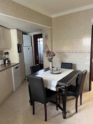 Una cocina moderna con una mesa de comedor, sillas y un refrigerador.