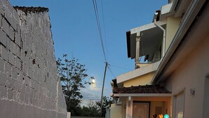 A narrow alleyway with a brick wall on one side and a building entrance on the other, leading to a set of stairs. - Sun And Ocean House With 2 Bathrooms (Alcobaça)