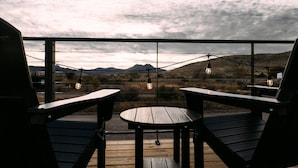 Une terrasse avec deux chaises et une table, offrant une vue sur un paysage montagneux.