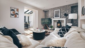 A modern living room with a sofa, a fireplace, and abstract wall art.