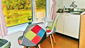 Een kleine keuken met uitzicht op een groen landschap.